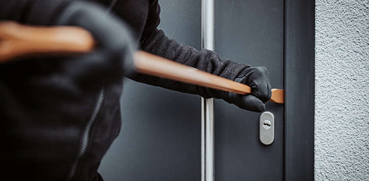 Detail of person breaking open a door with a crowbar.