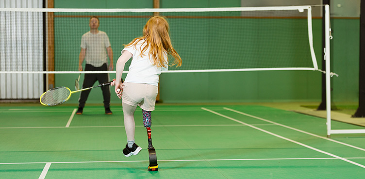 Barn med benprotes spelar badminton.