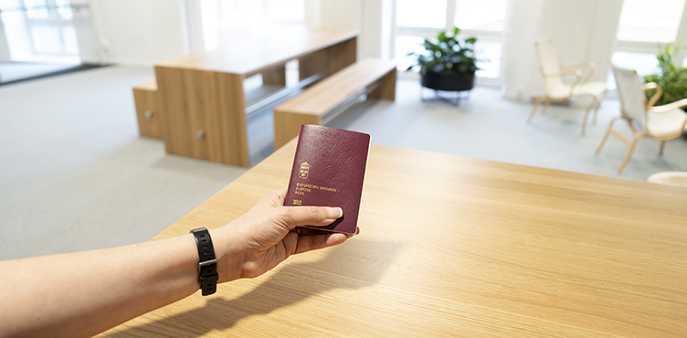 Hand som håller i svenskt pass.