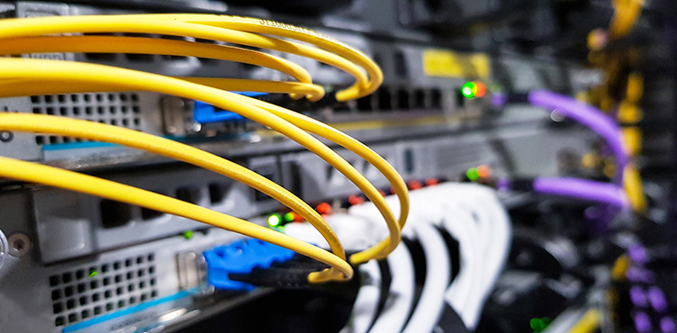 Närbild på färglada kablar som går in i utrustningen i ett modernt datacenter.